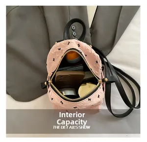 Rosa Mini-Rucksack mit Schleife zeigt Innenfach mit Handy, Kosmetik und Trinkflasche