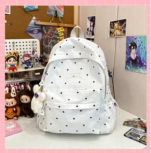 Close-up of white floral backpack with cute plush charm on a decorative desk