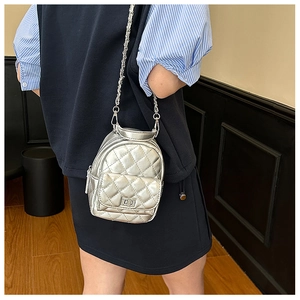Detail of silver quilted mini crossbody bag with metal chain strap and twist lock closure