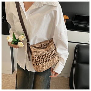 Detail of hand-woven straw tote bag with leather strap and wooden toggle closure