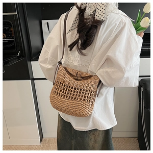 Detail of hand-woven straw tote with hollow pattern and retro wooden toggle closure