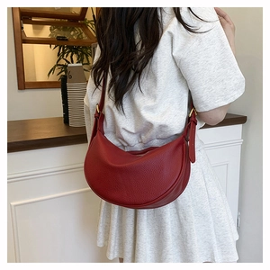 Nahaufnahme der roten Mondsichel-Tasche aus Leder mit Lychee-Muster und Goldbeschlägen