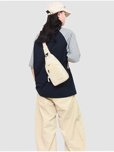 Détail du sac de poitrine beige avec logo KLEIMAN sur un tissu résistant à l'eau