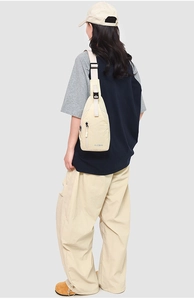 Vue détaillée du sac de poitrine en nylon beige avec sangle réglable et boucle noire