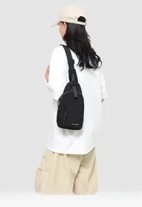 Détail de la sacoche de poitrine noire en nylon montrant le logo et la sangle
