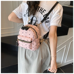 Detail eines rosa Rucksacks mit schwarzen Schleifen und verstellbaren Trägern