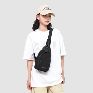 Détail d'un sac de poitrine en toile noire avec bandoulière réglable sur un mannequin