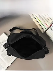 Aperçu de la capacité interne d'un sac bandoulière noir montrant la doublure spacieuse