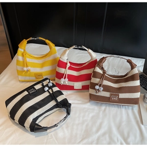 Overhead view of striped knit handbags in yellow, red, brown, and black with logo detail