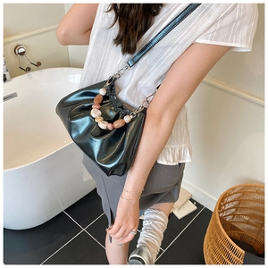 Dettaglio della pelle increspata e manico di perle su una borsa a tracolla alla moda