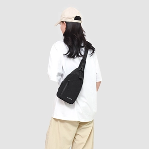 Détail de la bandoulière réglable et du logo blanc sur le sac de poitrine en toile noire