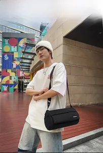 Vue de détail urbaine du sac bandoulière cylindrique noir en nylon avec sangle réglable