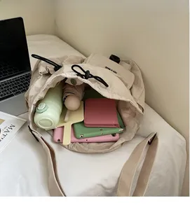 Innenansicht des großen Fassungsvermögens der cremeweißen Nylon-Beuteltasche mit Kordelzug