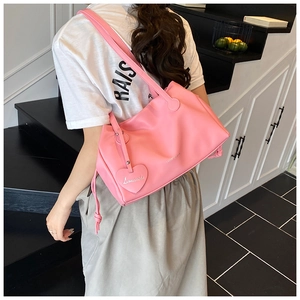 Pink pleated bucket bag with heart charm and drawstring detail shown from back view