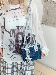 Deep blue denim bucket bag with silver studs and star charm on a shoulder strap