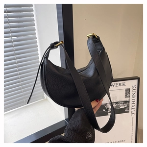 Nahaufnahme der schwarzen Mondsichel-Tasche aus Narbenleder mit goldener Schnalle