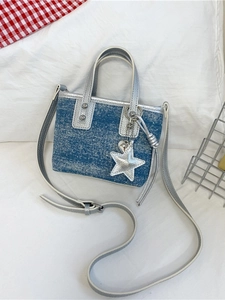 Mini denim bucket bag with silver glitter and star pendant on soft white background