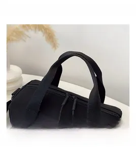 Détail du sac en nylon noir montrant les poignées larges et la fermeture éclair double