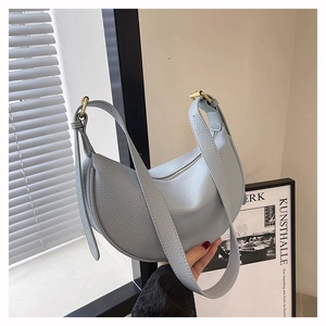Detail der hellblauen Handtasche aus Litschi-Leder mit breitem Gurt und Goldschnalle