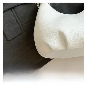 Detail of white lychee pattern leather shoulder bag with metallic buckle and texture