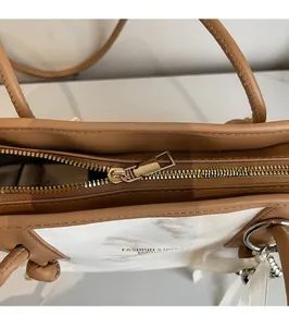 Dettaglio della cerniera in metallo dorato e cuciture su borsa a tracolla alla moda