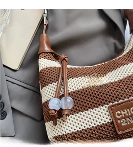 Close-up of striped knit underarm bag with CHIC leather patch and marble bead details
