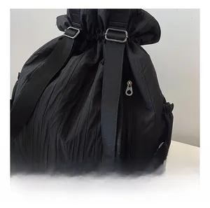Detail showing high-quality metal zipper and pleated waterproof fabric of a black backpack