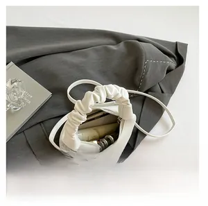 Interior view of white dumpling bag showing capacity for phone and cosmetics