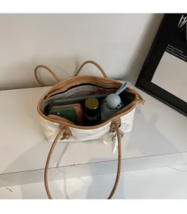 Vista dall'alto dell'interno spazioso di una borsa tote bianca marmorizzata con oggetti quotidiani