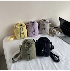 Cinq sacs à bandoulière en nylon imperméable avec cordon de serrage en différentes couleurs
