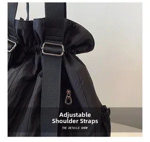 Close-up of adjustable strap and silver buckle on black nylon drawstring backpack