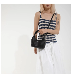 Détail du sac hobo en cuir grainé noir avec logo mode et poignée à effet froncé
