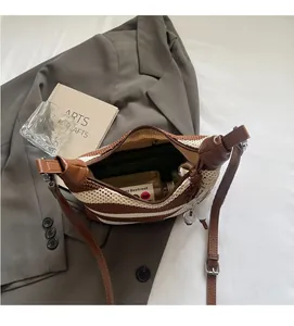 Detail view of woven striped crossbody bag showing interior capacity with cosmetics