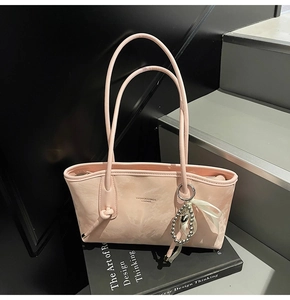 Dettaglio borsa tote rosa chiaro con ciondolo a cuore in perla e stampa di testo moda