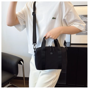 Détail du sac bandoulière noir avec logo DD argenté et bandoulière tissée réglable