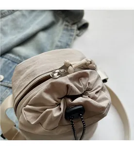 Détail de la fermeture éclair et du cordon de serrage sur le sac à bandoulière beige