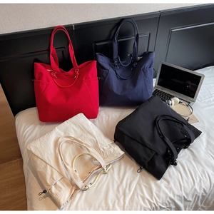 Detail of four colorful nylon tote bags with side drawstrings and double handles