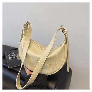 Detailansicht der hochwertigen Litschitextur auf der cremefarbenen Tasche mit Goldbeschlag