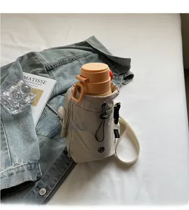Détail du sac à gourde en toile beige avec poche à cordon et bouteille de sport orange