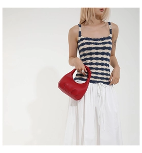 Détail du sac à main rouge plissé avec poignée froncée et texture en cuir premium