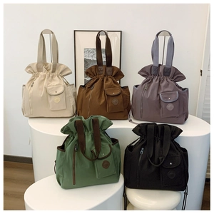 Detail view of five versatile pleated drawstring bucket bags in multiple stylish colors