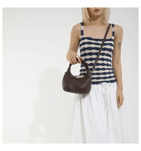 Détail du sac dumpling marron foncé avec poignée froncée et bandoulière sur mannequin