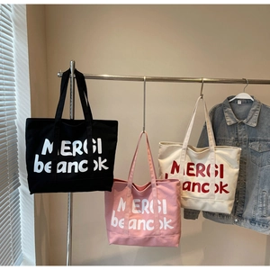 Three canvas tote bags in black, pink, and beige with MERCI letter print detail