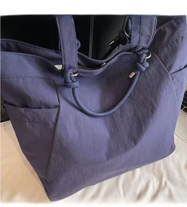 Detailed macro view of the navy blue tote bag with rope handles and textured fabric