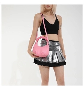 Sac croissant rose avec poignée froncée et texture grainée porté par un mannequin