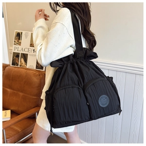 Macro shot of lightweight black drawstring bag with pleated texture and round logo