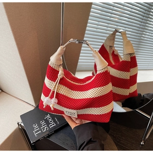 Detail of red and beige striped knit handbag with cream leather handle and metal hardware