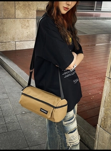 Détail d'un sac bandoulière cylindrique kaki avec sangle réglable sur un mannequin