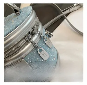Détail du sac seau en denim bleu avec strass argentés et fermeture éclair à cadenas