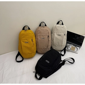 Detail shot of four small nylon backpacks in ginger, khaki, cream, and black colors